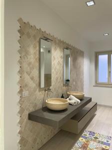 a bathroom with two sinks and two mirrors at Maison Mabette in Farigliano +47 photos