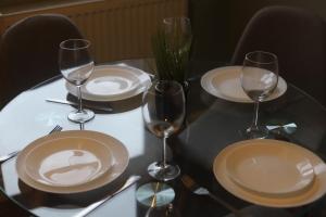 uma mesa com pratos e copos de vinho em Shamrock House- 2 BR House, Free Parking & WIFI em Ipswich