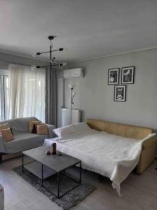 een woonkamer met een bed, een bank en een tafel bij Lovely Faliro Apartment next to the sea. in Athene