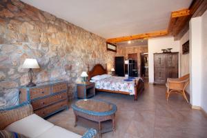 a bedroom with a bed and a stone wall at Aaccent Prenafeta Montblanc in Prenafeta