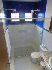 uma casa de banho com uma cabina de duche em vidro e um WC. em QUINTAL DA MATA em São Sebastião