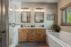bagno con vasca, lavandino e specchio di Eagle Creek Lodge a Big Bear Lake Altre 65 foto