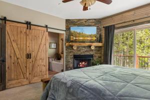 una camera da letto con camino, letto e finestra di Eagle Creek Lodge a Big Bear Lake