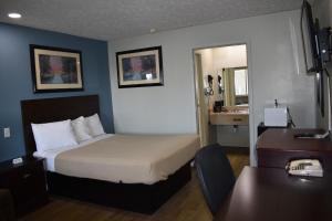 ein Hotelzimmer mit einem Bett und einem Schreibtisch in der Unterkunft Americas Best Value Inn Marion in Marion