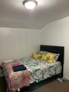 a bedroom with a bed with yellow pillows at Bangaly Guest House Newyork in Locust Manor