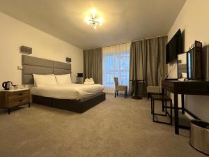 a hotel room with a bed and a desk at Exmouth Beach Hotel in Exmouth