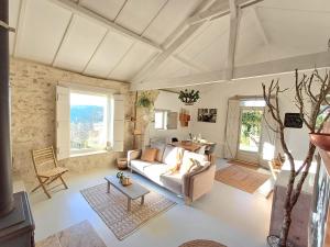 ein Wohnzimmer mit einem Sofa und einem Tisch in der Unterkunft Les Terrasses de Flaugnac in Flaugnac