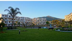 un parque frente a un gran edificio de apartamentos en Miradore golfe en Martil