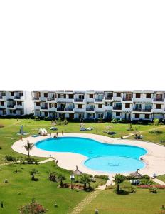 a large swimming pool in front of a large apartment building at Miradore golfe in Martil