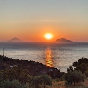 een zonsondergang over de oceaan met eilanden in de verte bij B&B Sunrise in Santa Marina Salina