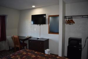 a hotel room with a desk and a television on the wall at Americas Best Value Inn Marion in Marion