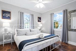 um quarto branco com uma cama e 2 janelas em Private Oasis W Two Houses 300 Steps to Beach em Galveston