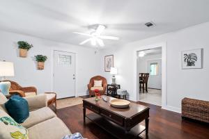 uma sala de estar com um sofá e uma mesa em Private Oasis W Two Houses 300 Steps to Beach em Galveston