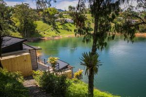 uma vista para um rio com uma casa e árvores em La Pausa Hotelbistro em Guatapé