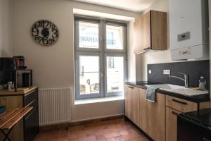 a kitchen with a window and a clock on the wall at Magnifique appartement hyper centre de Loches in Loches