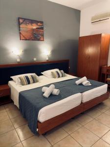a bedroom with two beds with towels on them at Stegna Sea & Sun in Archangelos