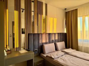 a bedroom with a bed and a desk and a mirror at Escape Pensiune in Bechet