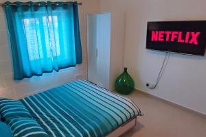 a bedroom with a bed with a netflix sign at Unique New Apartment - Victoria - Gozo in Victoria