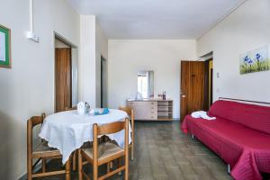 Habitación con mesa, cama y dormitorio. en Villa Collina, en Giardini Naxos