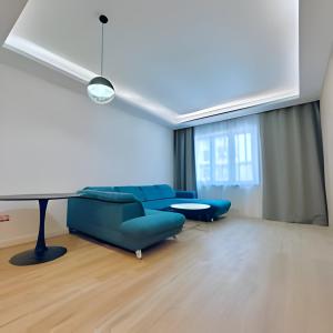 uma sala de estar com um sofá azul e uma mesa em New cool stylish apartment em Bratislava