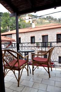 a patio with two chairs and a table on a balcony at Alkinoe Suite Arachova in Arachova