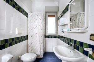 Un baño con inodoro, lavabo y espejo. en Villa Collina, en Giardini Naxos 84 fotos más