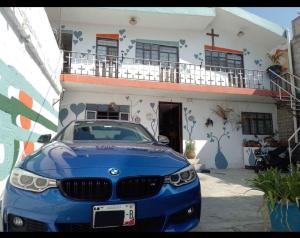 un coche azul estacionado frente a un edificio en Cuartos amueblados con servicios incluidos en Chapulco