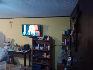 una habitación con TV y una cruz en la pared en Cuartos amueblados con servicios incluidos en Chapulco