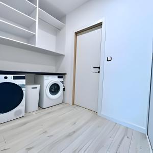uma lavandaria com uma máquina de lavar roupa e uma porta em New cool stylish apartment em Bratislava