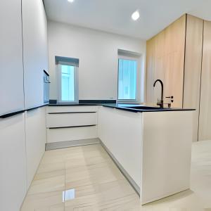 uma cozinha com armários brancos e um lavatório em New cool stylish apartment em Bratislava