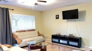 een woonkamer met een bank en een flatscreen-tv bij Spacious home sleeps 14 with pool table in Las Vegas