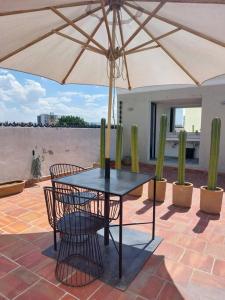 - une table et des chaises sous un parasol sur la terrasse dans l'établissement Casa Monarcas - Diana (with AC), à Guadalajara