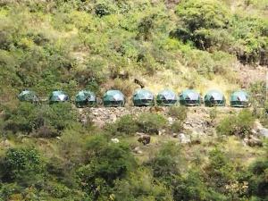 un groupe de tentes vertes sur le côté d'une colline dans l'établissement Sky Lodge Domes Chaullay, à Colcapampa