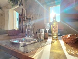 einen Tisch mit einer Flasche Wein und Gläsern darauf in der Unterkunft Les Terrasses de Flaugnac in Flaugnac