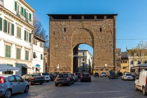 an arch in a city with cars parked on a street at Relax in San Frediano con giardino in Florence