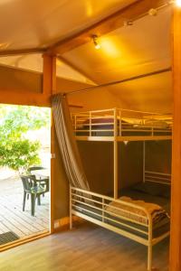 a room with bunk beds and a patio at Camping la Rouvière in Chame