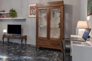 a room with a wooden cabinet and a desk with a laptop at Relax in San Frediano con giardino in Florence