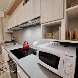una cucina con forno a microonde e bollitore per tè rosso di Casa Cavour a Osio Sotto