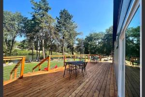 a wooden deck with a table and chairs on it at Loft Cabin 2 - Rogue River Resort in Grants Pass