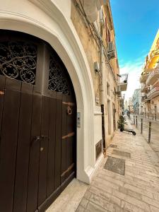 ein Torbogen mit einer großen schwarzen Tür auf einem Gebäude in der Unterkunft Palazzo Donnamaria in Manfredonia