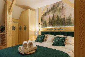 a bedroom with a bed with towels on it at Apartamenty Mrowca in Ząb