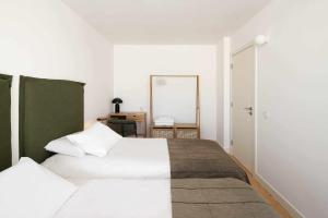 科英布拉的住宿－Apartamento Jardim Azul Downtown Apartments，一间卧室配有两张白色的床和镜子