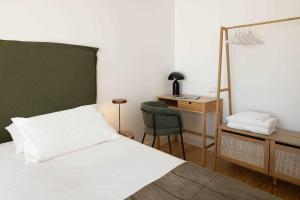 een slaapkamer met een bed, een bureau en een stoel bij Apartamento Jardim Azul Downtown Apartments in Coimbra