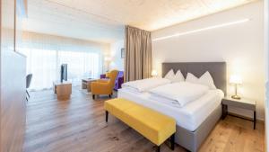 una camera d'albergo con un letto grande e una panca gialla di Seewirt Apartments a Klopein am Klopeiner See Altre 37 foto