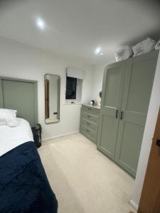 a bedroom with a bed and cabinets and a mirror at Modern 1 Bedroom House in Biggleswade in Biggleswade
