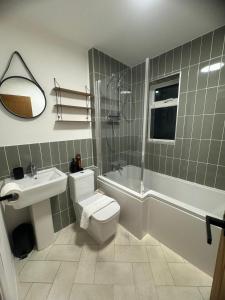 a bathroom with a toilet and a sink and a shower at Modern 1 Bedroom House in Biggleswade in Biggleswade