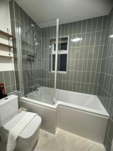 a bathroom with a tub and a toilet and a shower at Modern 1 Bedroom House in Biggleswade in Biggleswade
