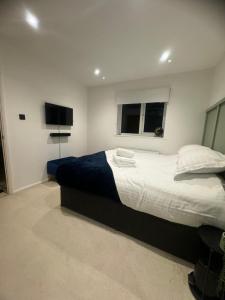 a bedroom with a large bed and a flat screen tv at Modern 1 Bedroom House in Biggleswade in Biggleswade