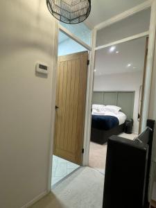 a bedroom with a bed and a door with a mirror at Modern 1 Bedroom House in Biggleswade in Biggleswade