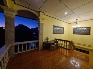 a room with a balcony with a table and a window at Saphaothong guesthouse in Vang Vieng